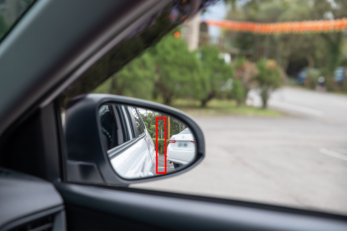 道路駕駛課程教學從右後照鏡可看到車體後門把與停靠車輛約一個拇指寬